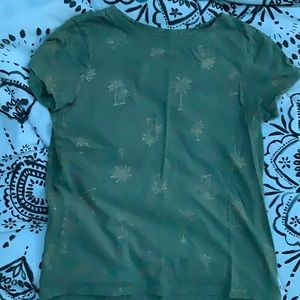 A green shirt with gold palm trees
